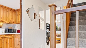 A kitchen with wooden cabinets, a microwave, and a dining area with a table and chairs.