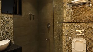 Un bagno moderno con doccia vetrata, un water e un lavandino.