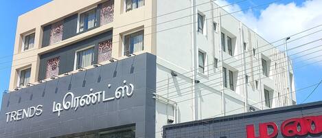 A multi-story building with signage for 'Le Prestige' and 'Trends'.