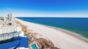 A beachfront hotel with a swimming pool, beach access, and ocean views.