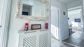 A hallway with a white console table, a large ornate mirror, and a framed picture. - Spacious 2 Bedroom flat with Balcony – 5 min to Kennington Tube, Central London (London)
