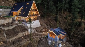 A modern house with a sloped roof, a balcony, and a small attached structure.