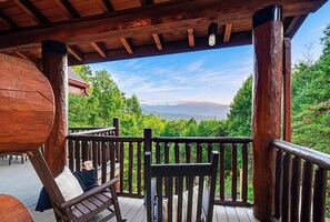 A wooden deck with a view of a mountainous landscape. - Round Log Cabin with Stunning Views (Gatlinburg)