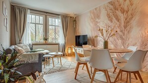Un salon moderne comprenant un canapé, une table à manger, des chaises et un téléviseur.