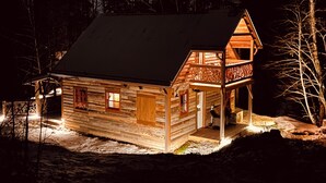 Een houten chalet met schuin dak, een veranda en een klein terras.
