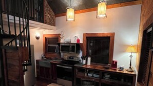 Een moderne keuken met houten details, een eethoek en een trap.