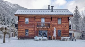 A wooden cabin with a balcony, a covered patio, and a view of snow-covered trees. - Chalet Verney. Family chalet near Chamonix center (Chamonix-Mont-Blanc)