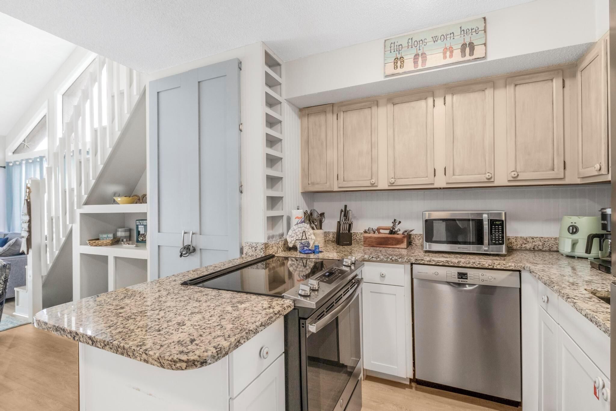 Eine moderne Küche mit Granit Arbeitsplatten, Edelstahlgeräten und Holzschränken.