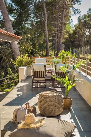 A patio with outdoor furniture, a woven basket, and potted plants. - Malibu Superior Apartment (Argostoli)