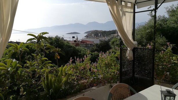 A terrace with a table and chairs, overlooking a mountainous landscape and a body of water. - Sunny apartment with view to the Mirabello Gulf (Agios Nikolaos)