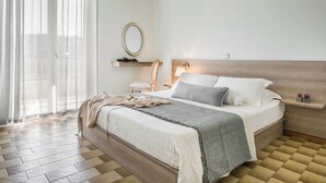 Ein ordentlich eingerichtetes Schlafzimmer mit Bett, Nachttisch und Spiegel.