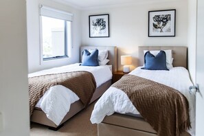 2 habitaciones, escritorio y tabla de planchar con plancha
