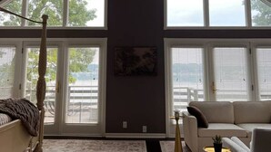Une pièce spacieuse avec un plafond haut, de grandes fenêtres, un ventilateur de plafond et un canapé moderne.