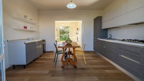 Una cocina moderna con una isla central, suelo de madera y armarios empotrados.