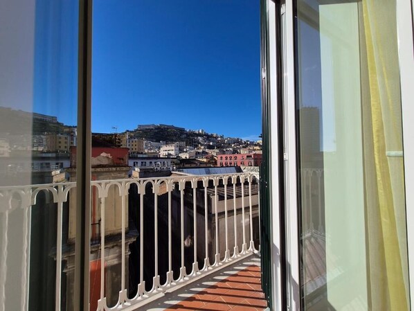 A balcony with a view of a cityscape, including buildings and a hill. - Appartamento Annunziata (Naples)