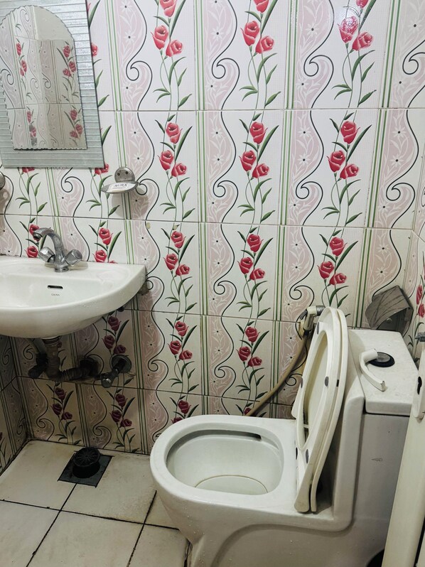 Une salle de bain avec un lavabo, des toilettes et un papier peint à motifs floraux décoratifs.