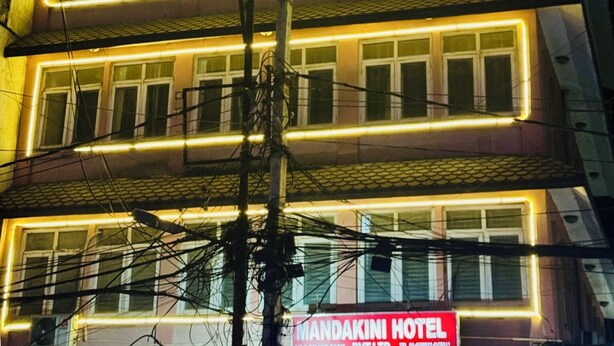 A multi-story building with illuminated neon lights outlining the windows and balconies. - Om Mandakini Hotel (Kathmandu)