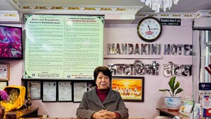 A reception desk at Mandakini Hotel Pvt. Ltd. with a clock, a chandelier, and a signboard with rules and regulations. - Om Mandakini Hotel (Kathmandu)