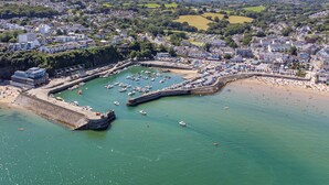 An aerial view of a coastal town with a marina, sandy beach, and residential areas. - 2 Beach Court - Direct Beach Access, Sea Views (Saundersfoot)