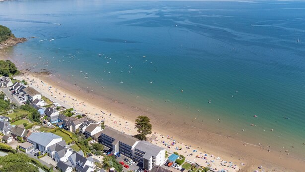 An aerial view of a coastal town with a beach, houses, and a large body of water. - 2 Beach Court - Direct Beach Access, Sea Views (Saundersfoot)