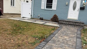 A residential house with a paved driveway, a white picket fence, and a mailbox. - Marvelous basement apartment with WiFi in Elmont (Elmont)