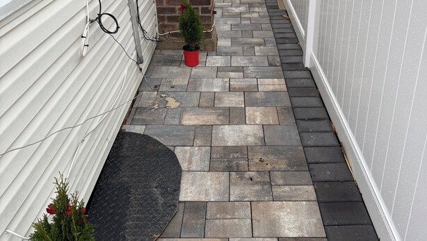 A narrow pathway with a brick wall, a white fence, and potted plants. - Marvelous basement apartment with WiFi in Elmont (Elmont)