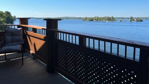 A wooden deck with a view of a lake and distant islands. - Fabulous cottage suite, spectacular Stoney Lake view! (Douro-Dummer)