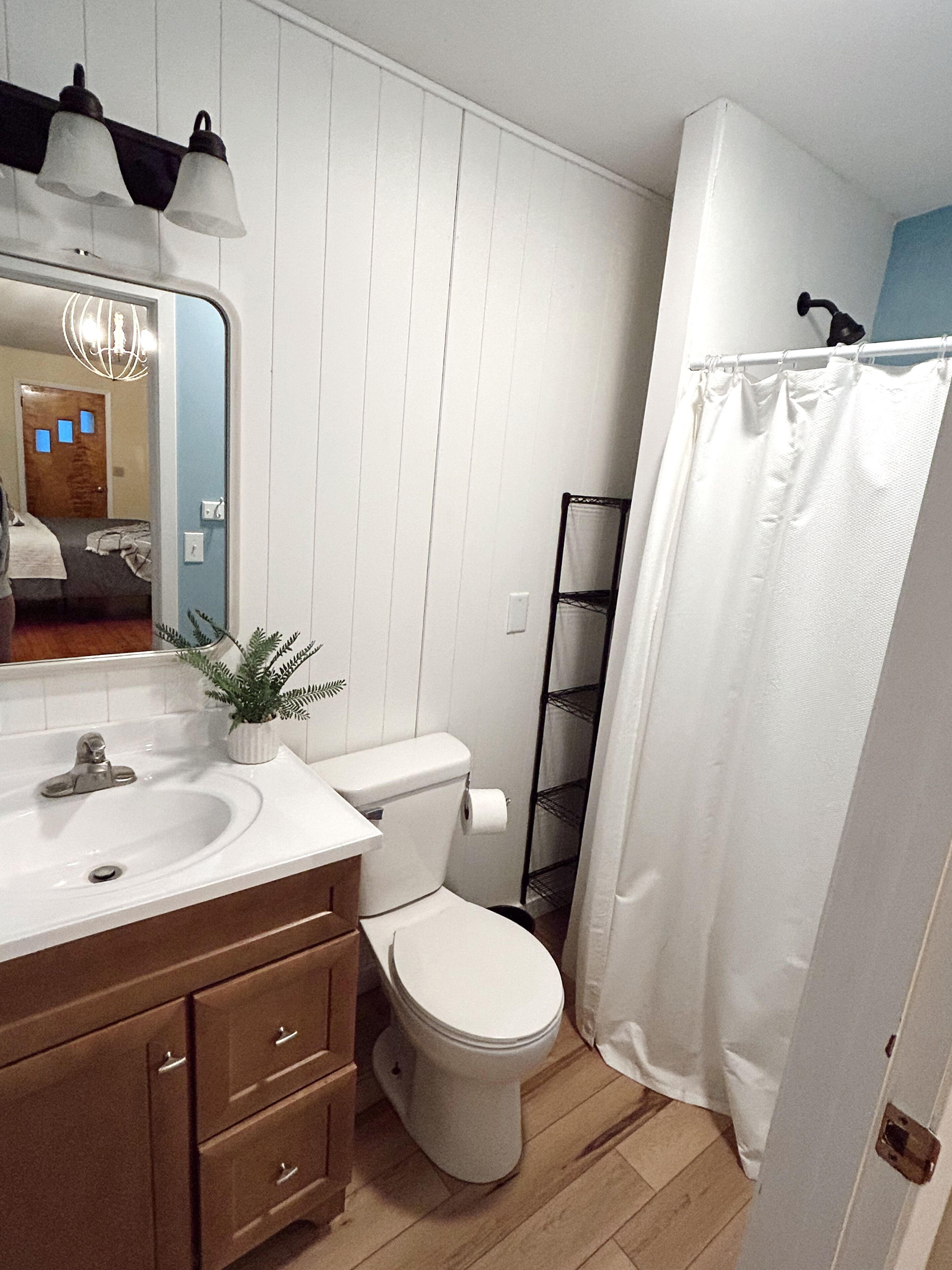 A bathroom with a white sink, a toilet, and a shower curtain.