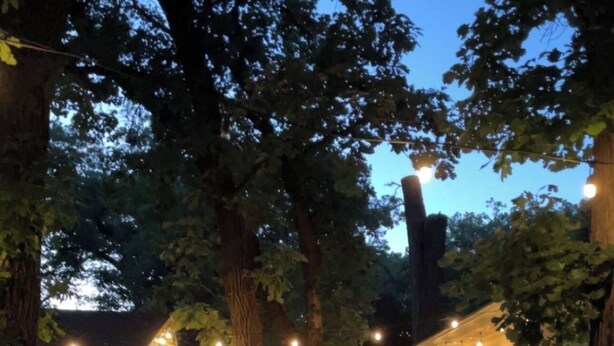 Une terrasse agrémentée de guirlandes lumineuses, de mobilier d’extérieur et d’une petite piscine.