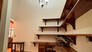 A room with a sloped ceiling, wooden beams, a chandelier, and built-in shelves. - Congo House (Provincia de Guanacaste)