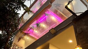 Ein modernes Gebäude mit Glasfassade, einem Balkon mit schmiedeeisernen Geländern und einer Steinwand.