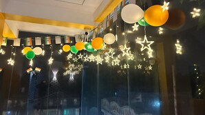 Ein Zimmer mit einem großen Fenster, dekoriert mit leuchtenden Sternen und Ballons.