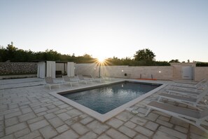 A rectangular swimming pool with a stone border, surrounded by lounge chairs and a stone wall. - Zen Garden Villa with heated pool (Posedarje)