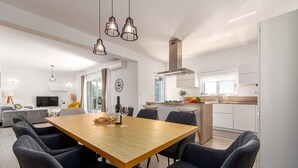 Un espace de vie moderne comprenant un coin repas, une cuisine et un coin salon.