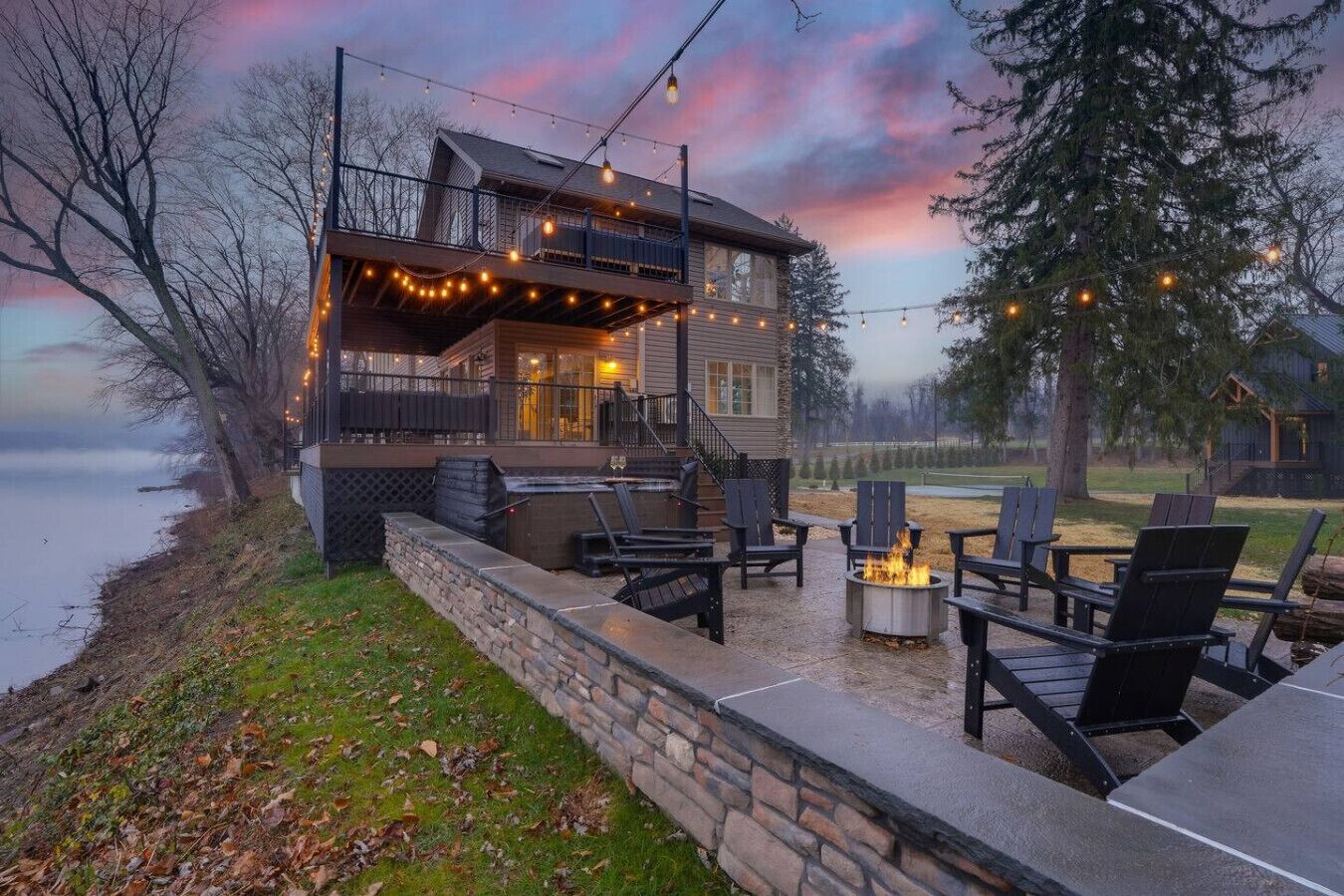 Un chalet au bord du lac, doté d’un espace extérieur aménagé et d’un foyer.