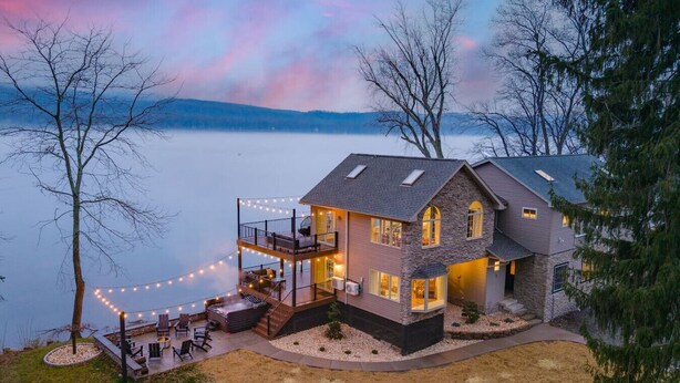 A two-story house with a balcony, outdoor seating, and string lights. - Riverside Retreat  Sleeps 20 (Halifax)