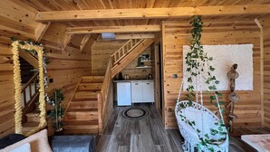 Ein Holzhütten-Innenraum mit einer Treppe, die zu einem Küchenbereich führt.