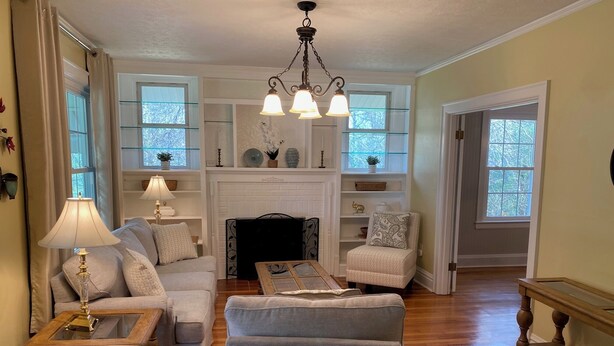 A living room with a fireplace, a sofa, a chair, and a coffee table.