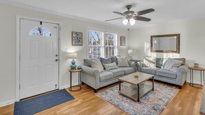 A living room with a grey sofa, a coffee table, and a ceiling fan. - Covered patio, finished basement, amazing location (Overland Park)