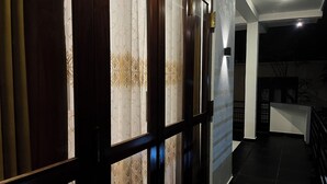 A hallway with a wooden door and a glass partition with a floral pattern. - Galle Nature Nook (Galle)