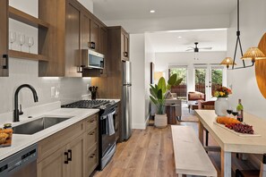 A modern kitchen with wooden cabinets, stainless steel appliances, and a central island.