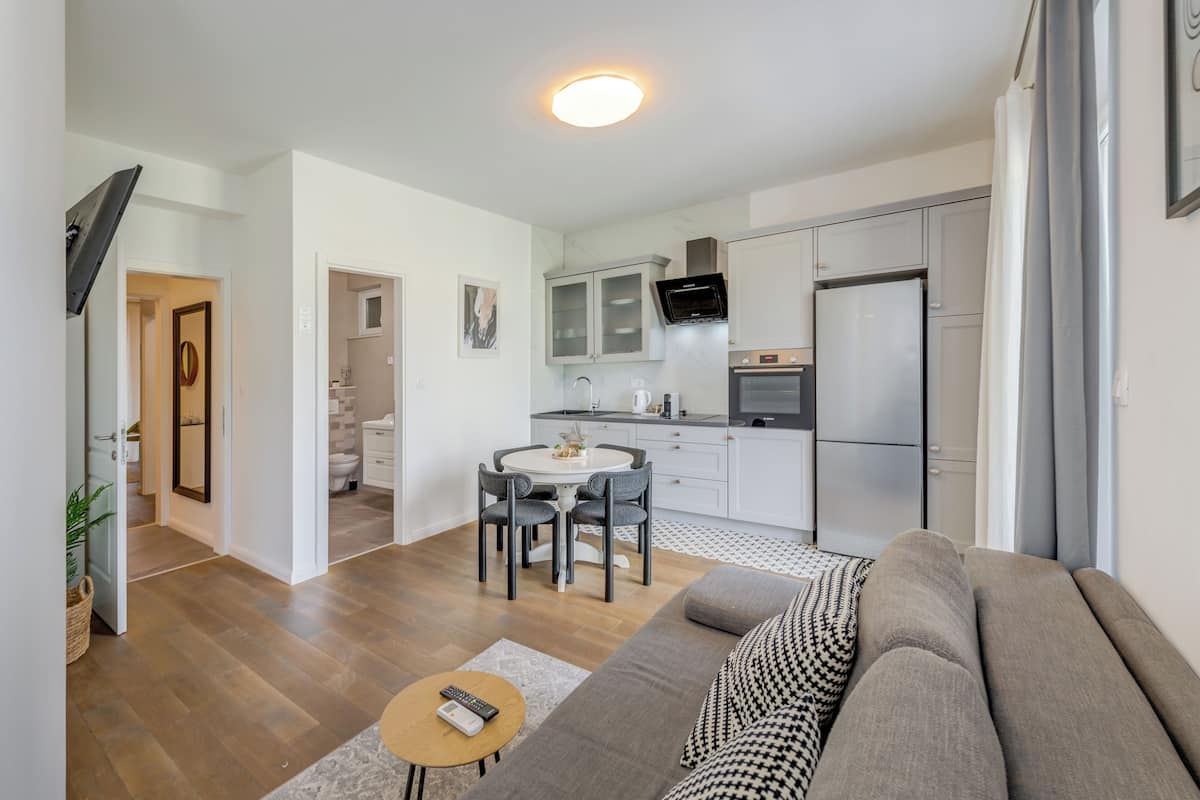 A modern apartment with a living room, kitchen, and dining area.