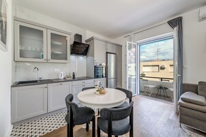 Een moderne keuken met een eetgedeelte, een ingebouwde oven en een koelkast.