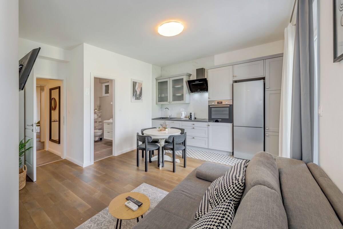 A modern apartment with a living room, kitchen, and bathroom.