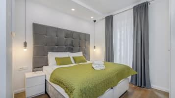 Deluxe tweepersoonskamer | Een kluis op de kamer, een bureau, verduisterende gordijnen