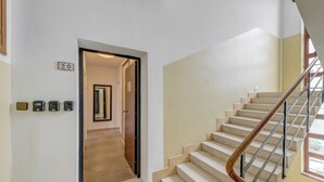 A staircase with a wooden handrail and beige steps, leading to an upper floor. - Finn Luxury Rooms (Split)