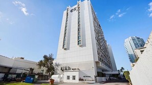Un grand bâtiment blanc, sur lequel on peut lire l’inscription « esj » en haut.