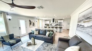 A modern living room with a grey sofa, a coffee table, and a large painting.