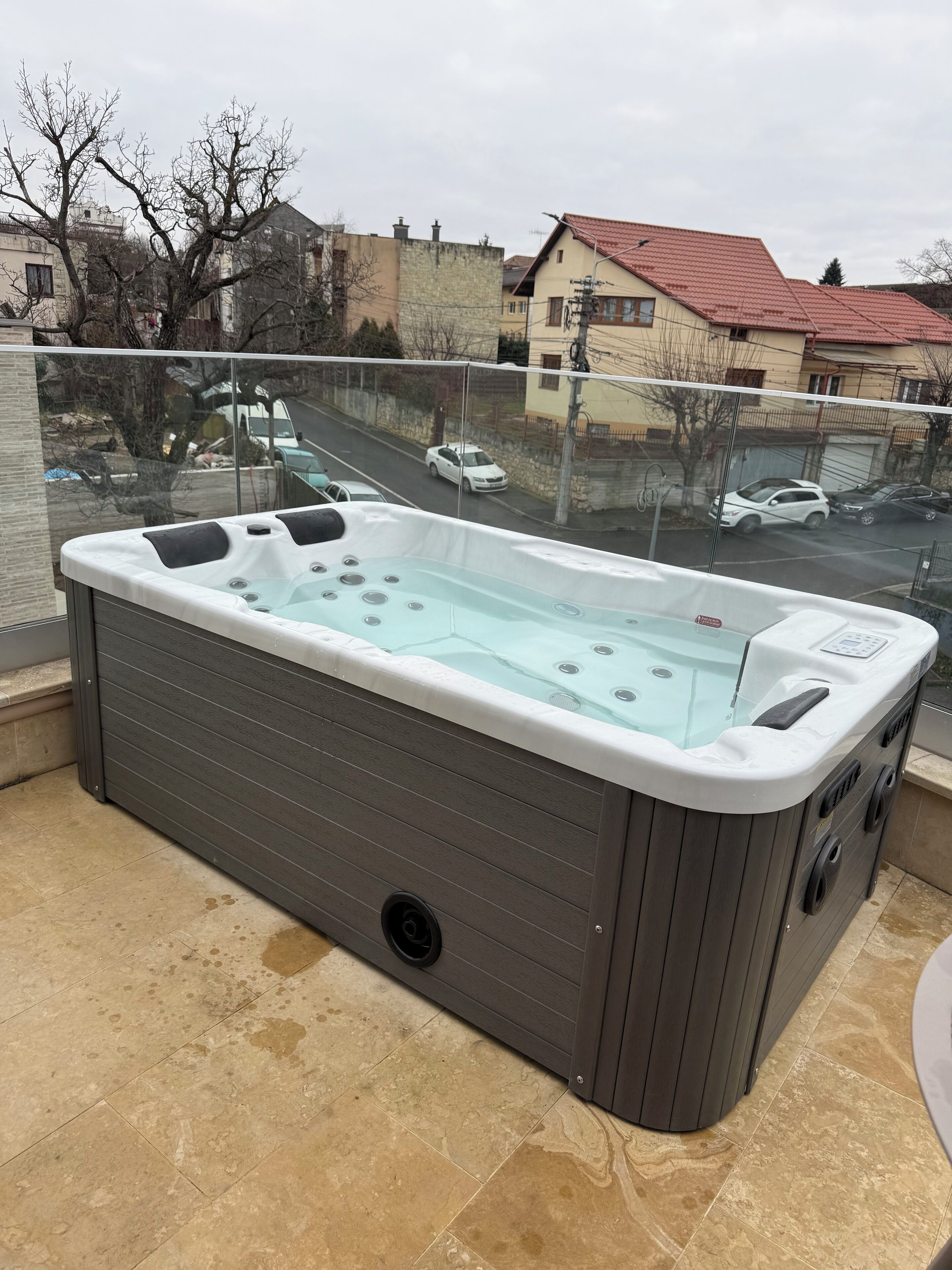 A hot tub on a balcony with a view of a residential street.