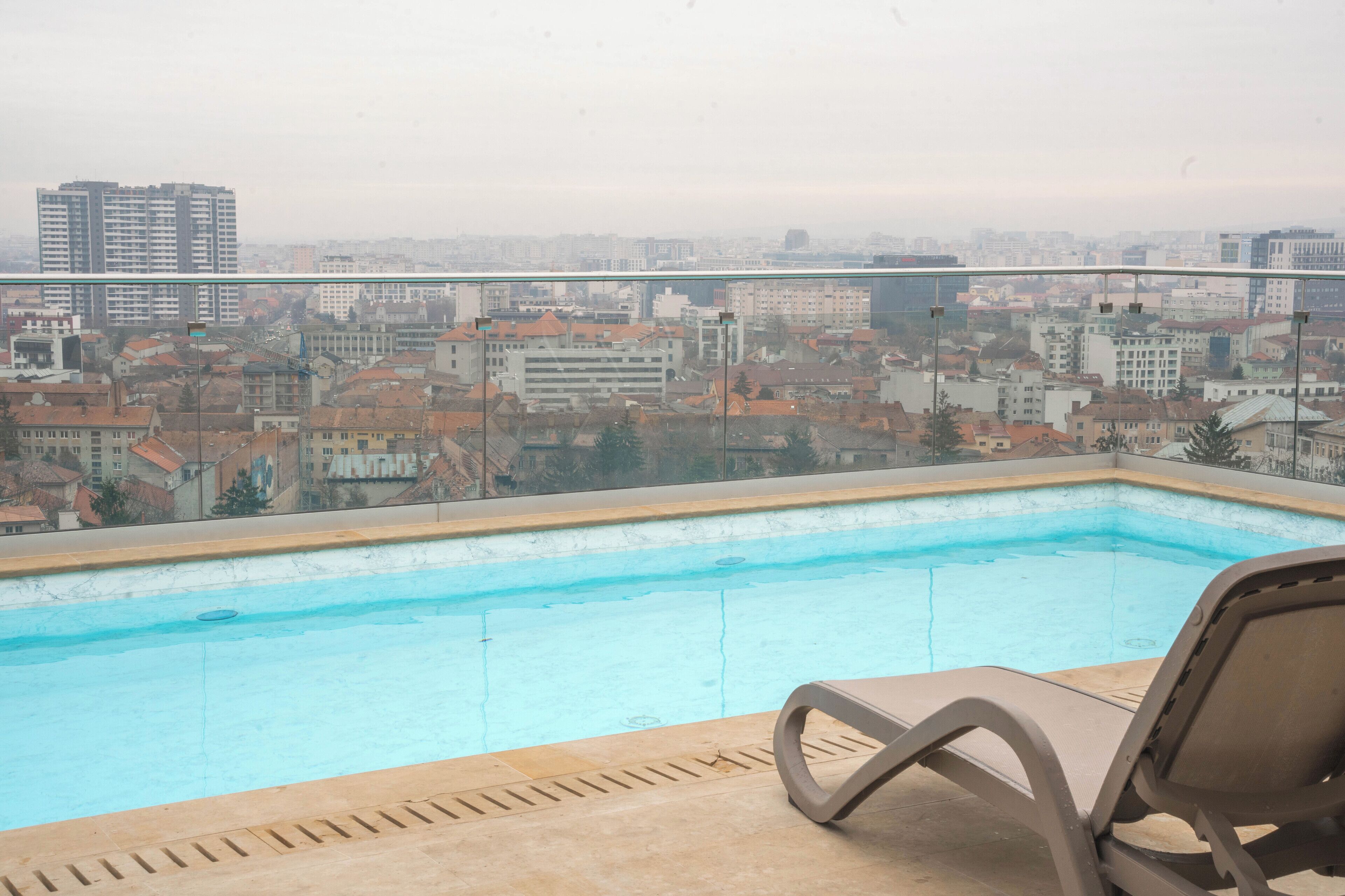 A rooftop pool with a view of a cityscape.